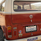 Red Volkswagen van with 'DEADED' license plate in a rural setting